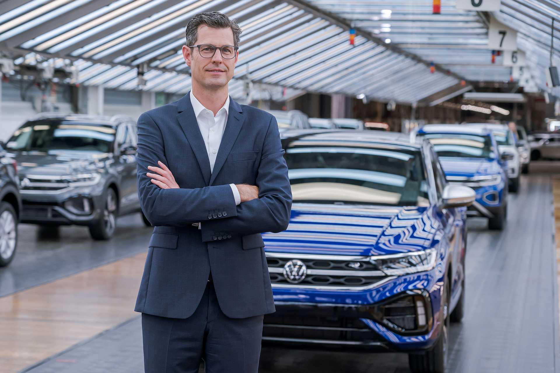 Thomas Hegel-Gunther in front of blue T-Roc inassembly shop